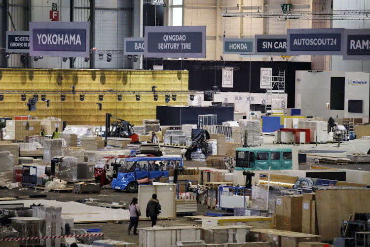 Workers pack crates as they dismantle stalls at Palexpo, the venue for the cancelled Geneva International Motor Show in Geneva, Switzerland, on Saturday, Feb. 29, 2020. Organisers have announced that the show has been postponed until 2022.