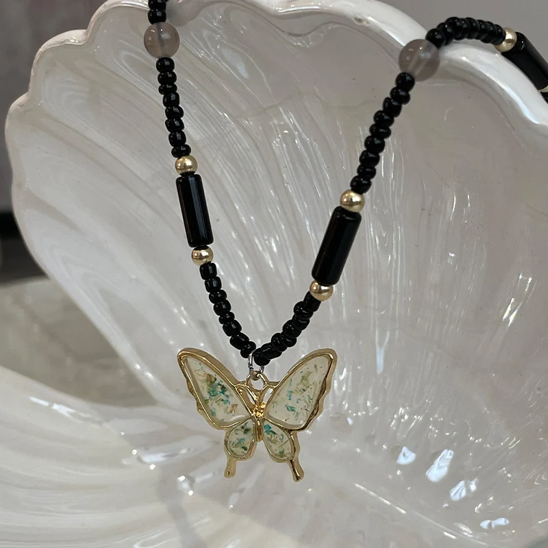 Collier pendentif papillon perlé noir Un bijou élégant pour femme Charme et sophistication Collier papillon pour un look unique.