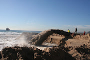 A slurry of sand and seawater spews from a temporary ship-to-shore pipeline as part of an emergency scheme to replenish beach sand along Durban’s Golden Mile.