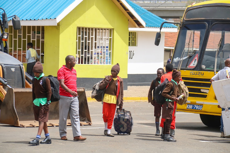 Parents and guardians assemble to receive their kids dropped by school buses at Green Park bus terminal on November 22, 2022.