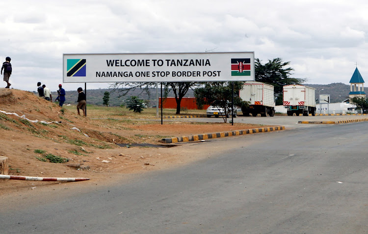 Children walk past a signage at the border crossing point between Kenya and Tanzania in Namanga, Tanzania July 19, 2019.