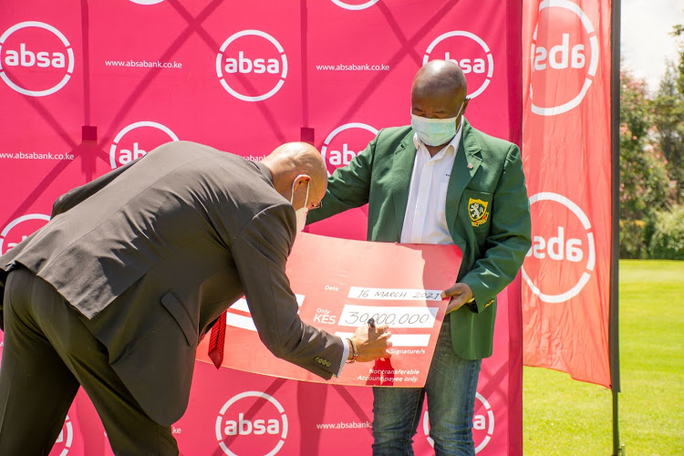 Kenya Open Golf Limited (KOGL) Tournament Director, Patrick Obath receives a sponsorship cheque from Absa Managing Director Jeremy Awori