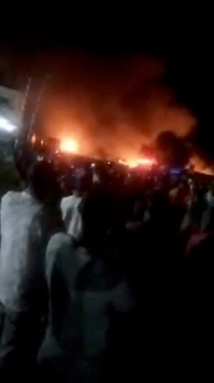 People look as a fire blazed following a fuel tanker explosion in Freetown, Sierra Leone on November 5, 2021.
