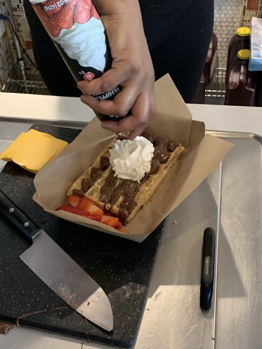 Gluten-free waffle with Nutella, strawberries and whipped cream