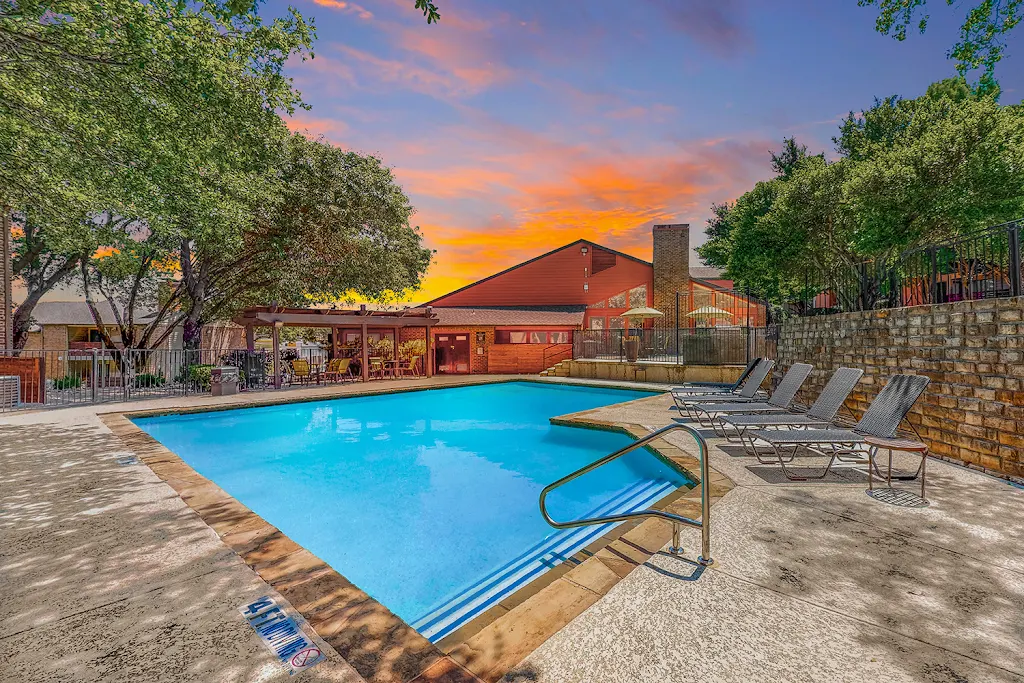 Silverton's refreshing swimming pool with trees surrounding and lounge chairs at dusk