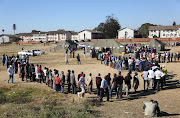 FILE IMAGE: Voters queue at a polling station in the Mbare district in Harare, Zimbabwe. 