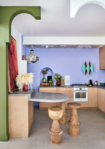 The use of graphic colour blocking makes this small open-plan kitchen feel spacious and playful.