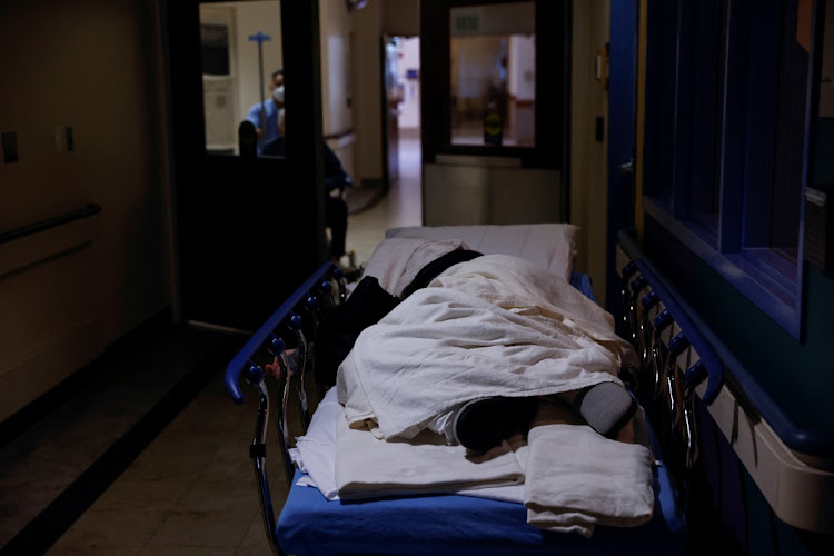 A patient lays on a medical gurney waiting to be seen in the emergency room waiting area at Providence Mission Hospital in Mission Viejo, California, US, January 27, 2022.