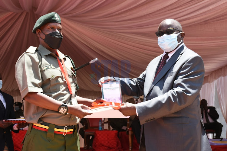 Kenya Film Commission CEO Peter Mutie awards Kamiti Maximum Prison Senior Sergeant Paul Omondi with a graduation certificate at KFC school on September 29, 2021. PHOTO/MERCY MUMO