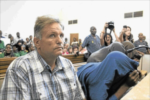 EERILY CALM: Johan Kotze, the man who orchestrated the attack on his wife holds his breath in a courtroom filled with venomous hatred. The co-accused sit next to him. PHOTO: Bongani Mnguni. File photo