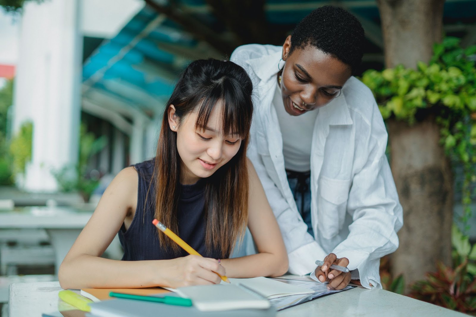 Student sat at a table and tutor standing over, preparing for the UCAT test 2023