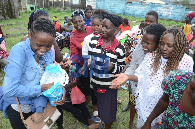 OCTRE legal director Njeri Kagia distributes diapers to mother who attended the workshop on May 28, 2022.