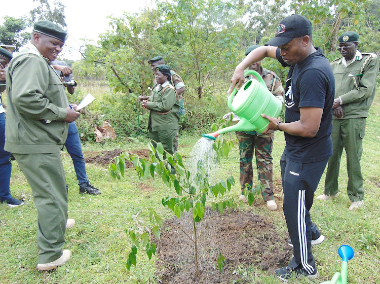 The National Drought Management Authority chairman Raphael Nzomo with forest rangers at the Kakamega Forest on Saturday.