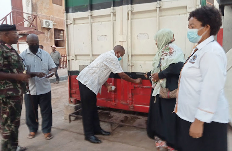 Lamu county deputy county commissioner Charles Kitheka opens the exam container in Lamu island.