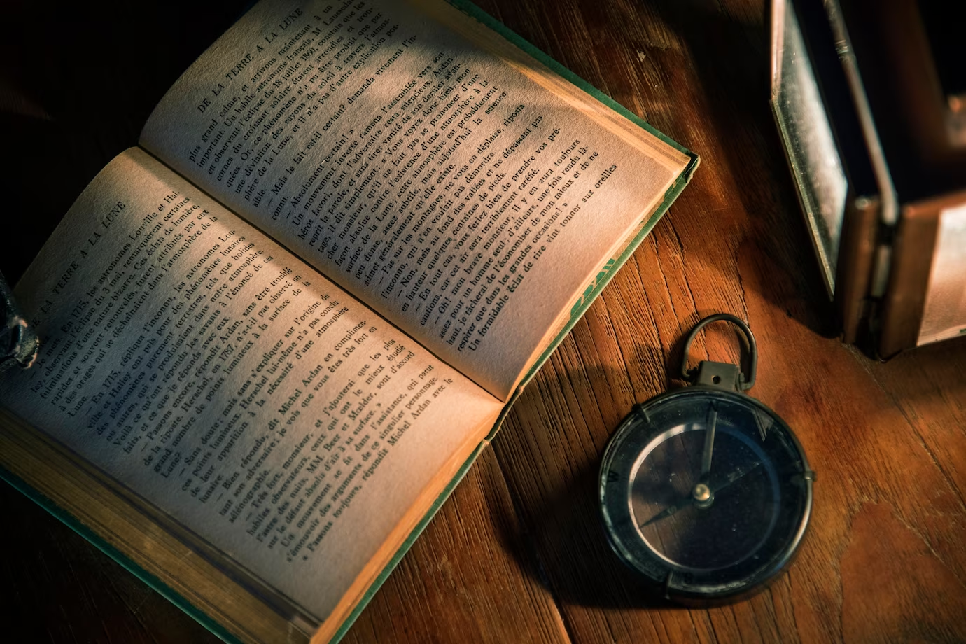 A vintage book lying on a wooden table, representing the importance of reading in academia and the valuable knowledge found within books.