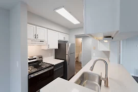 Kitchen with stainless steel appliances, light color cabinets, light-colored countertops, and open layout.