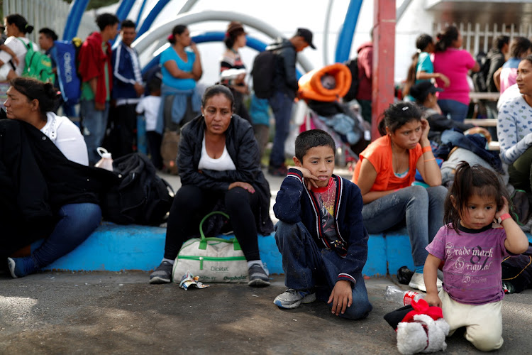 Migrants, part of a caravan traveling en route to the United States, wait in lines to enter in a sport center that is currently used as a temporary shelter in Tijuana, Mexico November 15, 2018.