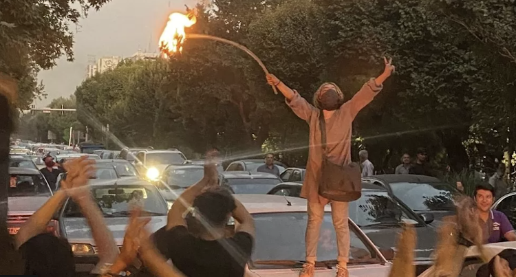 A woman set fire to her headscarf during a protest in Tehran on Monday