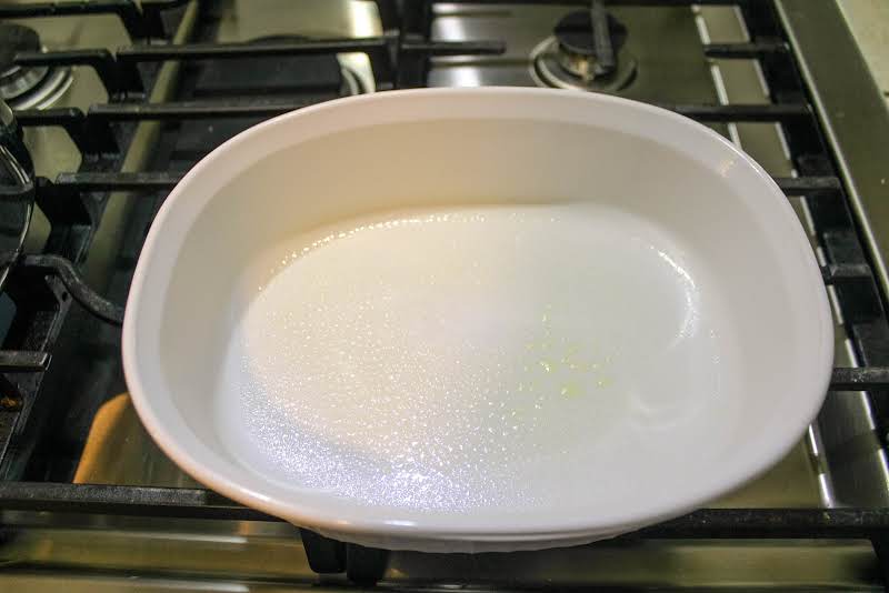 Greased Casserole Dish On A Preheating Oven.