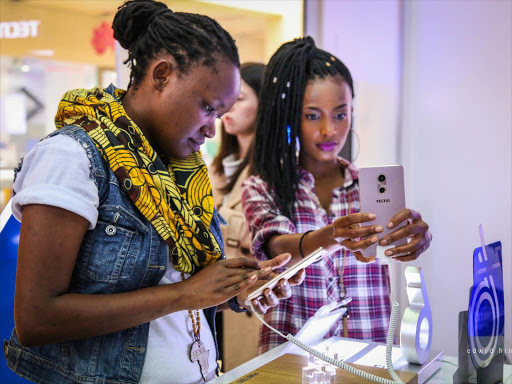 Musician Fena Gitu, brand ambassador of Tecno Watch Me Grow Campaign, has a feel of the new Tecno Phantom 6 device at Garden City Mall, October 8, 2016. /FRANK MUCHUGU