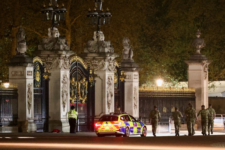 Police officers and security force guards at the gates of Buckingham Palace after a man was arrested on May 2 2023 for throwing what police believe were shotgun cartridges.