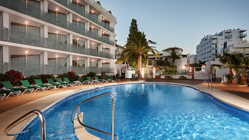 a large swimming pool in front of a hotel