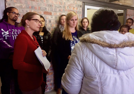 Attorneys Tracey Davies (left) and Christine Reddell (right) receive a summons from the Cape Town Sheriff at the Centre for Environmental Rights.