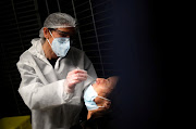 A medical worker, wearing a protective suit and face mask, administers a nasal swab to a patient at a coronavirus disease (Covid-19) testing centre in Le Bignon, France, December 22, 2020. 