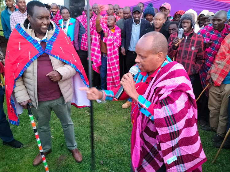 Narok South legislator Kitilai ole Ntutu (left) with former Laikipia North MP Mathew Lempurkel(right) during Ita ole Kiok's graduation ceremony for masters degree at Entiani area of Mau Narok region in Narok county.