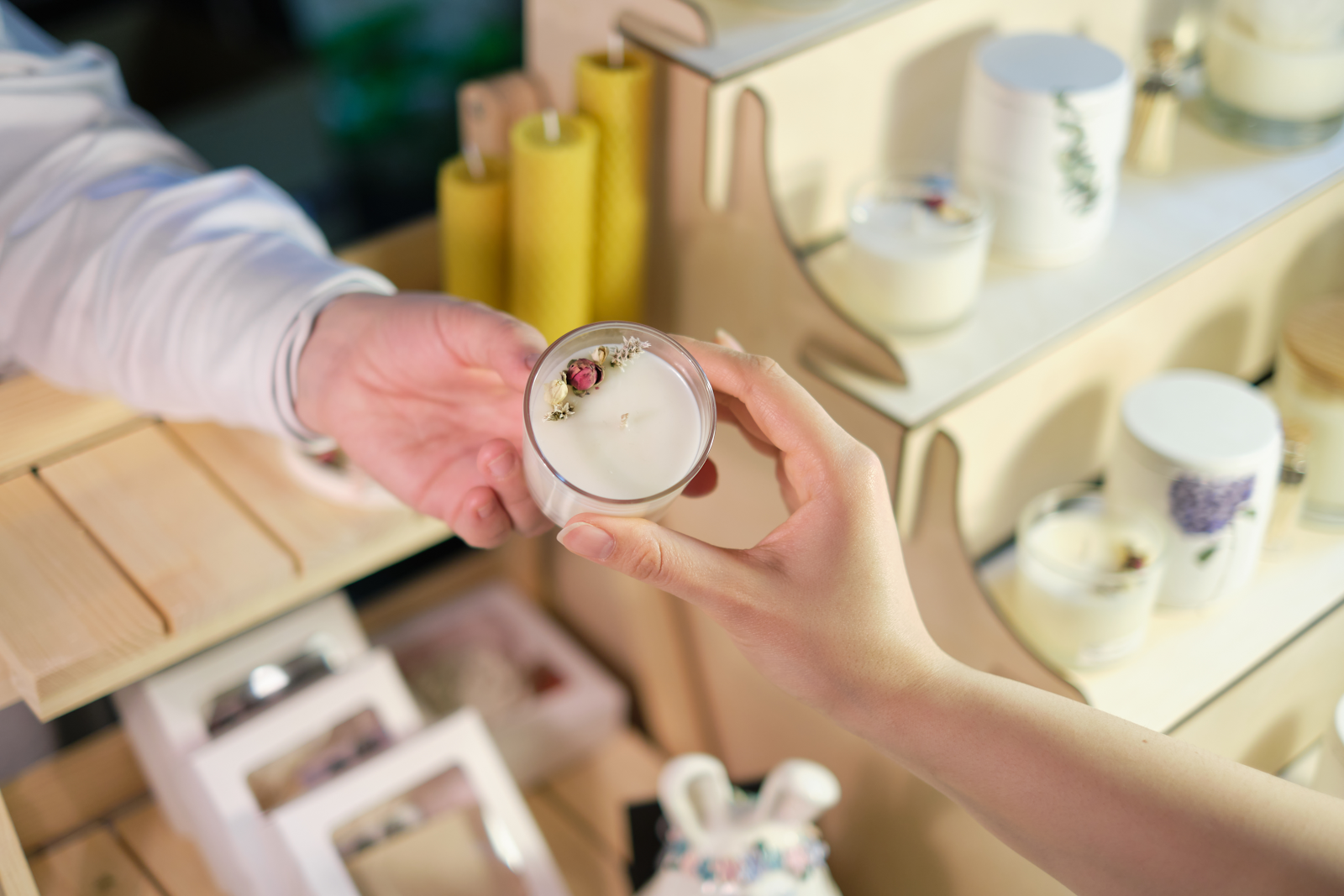 A customer looks at a candle at a pop-up event