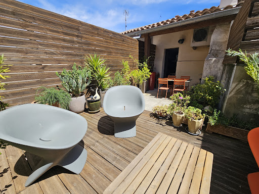 Wooden terrace with armchairs and plants in this luxury property for sale in Aigues-Mortes ($503,528 - 105 m²)