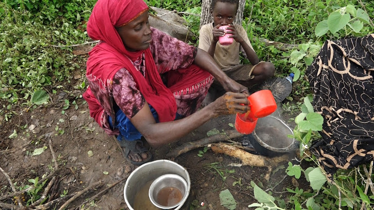A Woman prepares strong tea for her children at their IDP camp which had rained before they managed to build a makeshit at Centre area near Garsen Tanariver County
