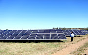 Rural Free State GM Gugu Mokoena walks next to the solar panels that help light up Frankfort. The town will have to stop relying on these solar panels during load-shedding in a system called 'voiding' because of Eskom's objections.