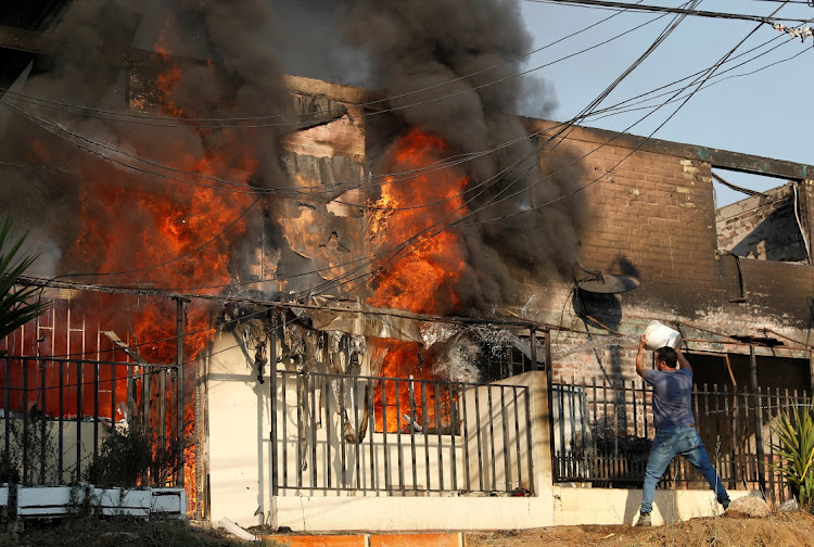 A man tries to extinguish a burning house during the spread of wildfires in Vina del Mar, Chile February 3 2024. Picture: RODRIGO GARRIDO/REUTERS