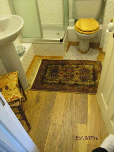 Laying of wooden floor in living room, hall and bathrooms.