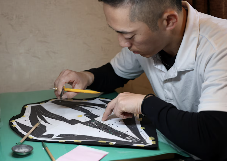 Kenji Tanaka works to produce a Formula One paper model with the traditional craft Ise Katagami in Suzuka, Japan in March 2024.