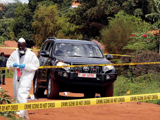 Ugandan investigators are seen working at the cordoned off scene in Kampala where assistant Inpector General of Police Felix Kaweesi and two others were killed, March 17, 2017. /REUTERS