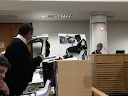 John Loud, Ford's principal forensic investigator in the Kuga fire inquiry, being questioned by Ford's legal counsel André Bezuidenhout in the Cape Town High Court. Next to him is the body control mechanism and the front half of a Ford Kuga.