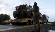 An Israeli soldier overlooks a tank relocation in Alonei Habashan in the Israeli-occupied Golan Heights, on November 11, 2012. Israeli troops fired warning shots into Syria in response to mortar fire, the army said, in the first Israeli fire directed at the Syrian military in the Golan Heights area since the 1973 war.