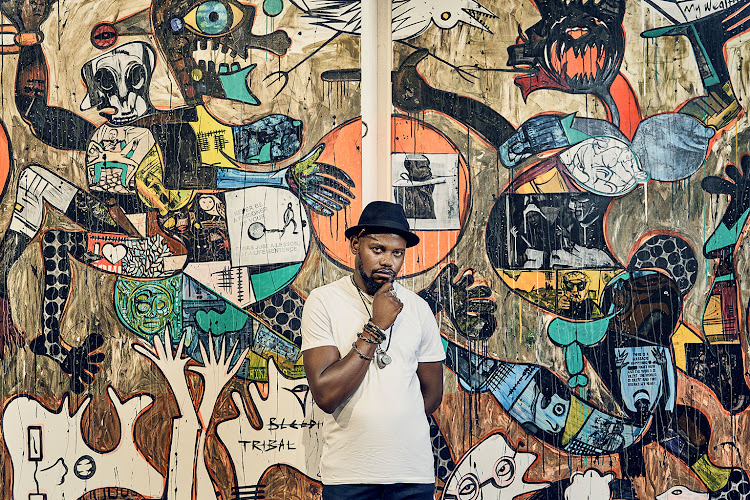 Blessing Ngobeni stands in front of his artwork, Bleeding Tribal Political Influence (2019).