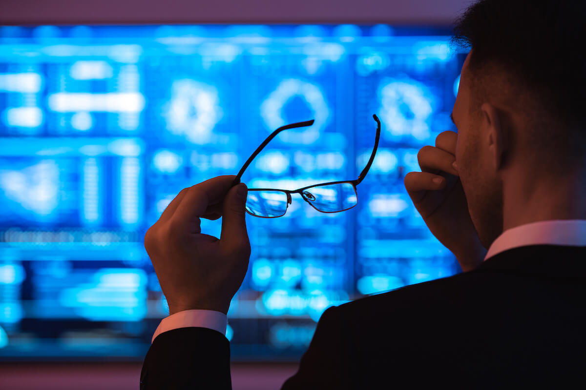 Working conditions: tired man massaging his nose bridge while holding his glasses