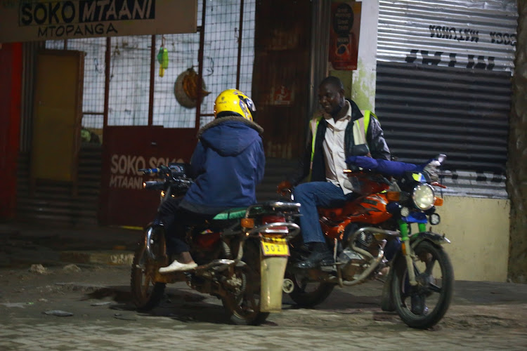 Boda boda operators wait for customers during curfew hours in Bamburi, Mombasa county.