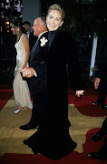 Sharon Stone arrives at the 1996 Oscars  in a Valentino skirt and a Gap mock neck T-shirt. 