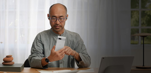 A man using a Google Pixel phone in his office.