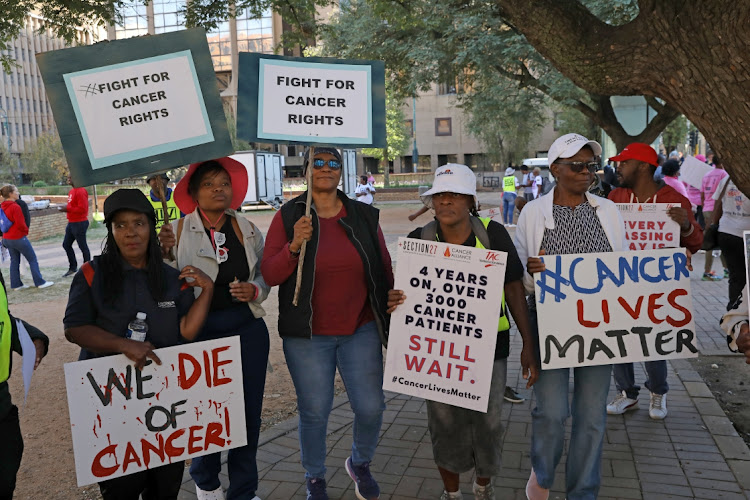 Protesters hold placards demanding the Gauteng health department do more in its fight against cancer.