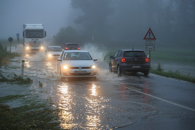 Vehicles travel on a flood affected road after the Erft river swelled following heavy rainfalls in Erftstadt, near Cologne, Germany, July 15, 2021.