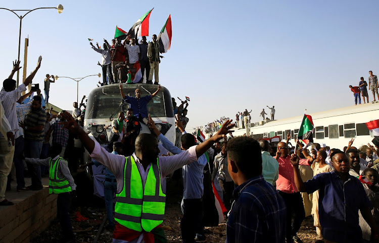 Sudanese demonstrators welcome a train carrying protesters from Atbara, the birthplace of an uprising that toppled Sudanese former President Omar al-Bashir, as it approaches the military headquarters in Khartoum, Sudan on April 23, 2019.