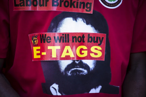 Stickers are placed over the face of Neil Agett on a Cosatu t-shirt. Picture Credit: Gallo Images