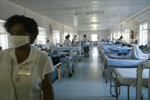 A nurse wearing a face mask walks out of the mens TB ward in Church of Scotland Hospital Msinga.