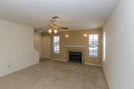 Apartment front entrance with tile flooring leading to the carpeted living area with a fireplace